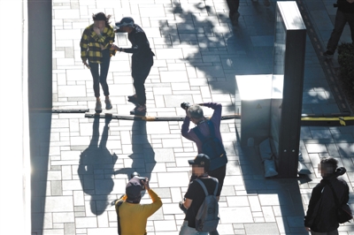 5月19日下午，三里屯太古里，男街拍爱好者拉扯经过的年轻女性要求拍摄，另两位街拍爱好者不停拍摄该女性。