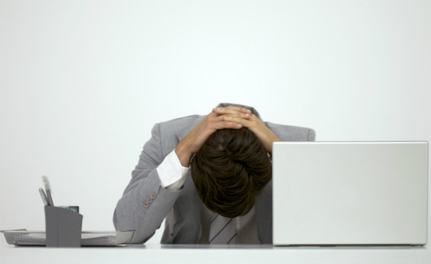 Businessman sitting at desk with head down